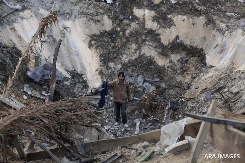 A Palestinian man inspects damage at a training site for the Al-Quds Brigades, the military wing of Islamic Jihad on January 14, 2014 after it was hit by an Israeli air strike in Khan Younis in the southern Gaza Strip th...