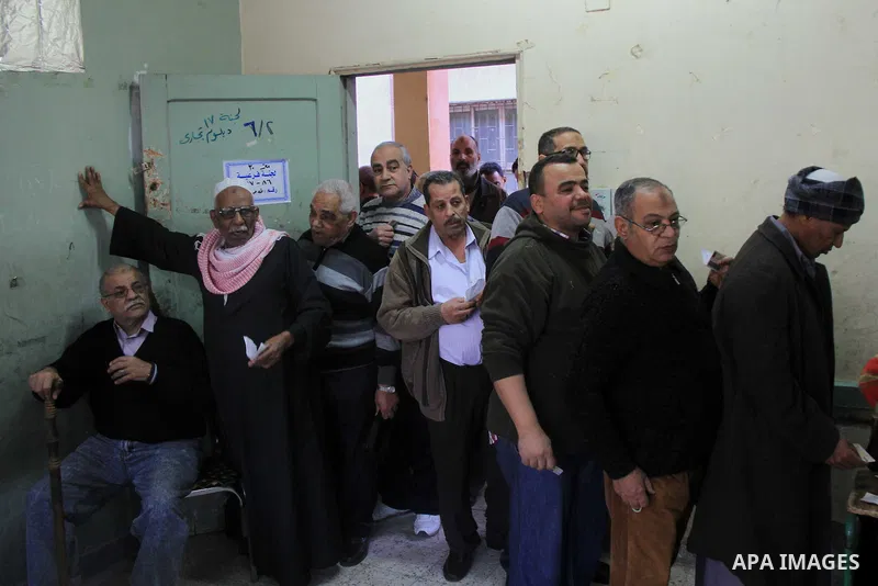 Egyptians wait to cast their vote during the referendum on the draft constitution, outside a polling station in Cairo, Egypt, 14 January 2014. Egyptians began on 14 January to vote on a new constitution drawn up after th...