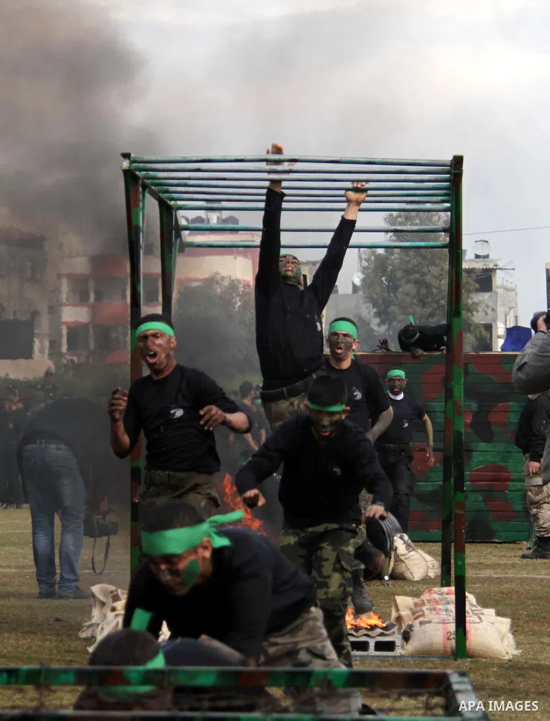 Palestinian students take part in a graduation ceremony for a military-style training programme in Gaza City on January 14, 2014. Some 13,000 students joined the course, which is aimed at preparing them for "liberating P...
