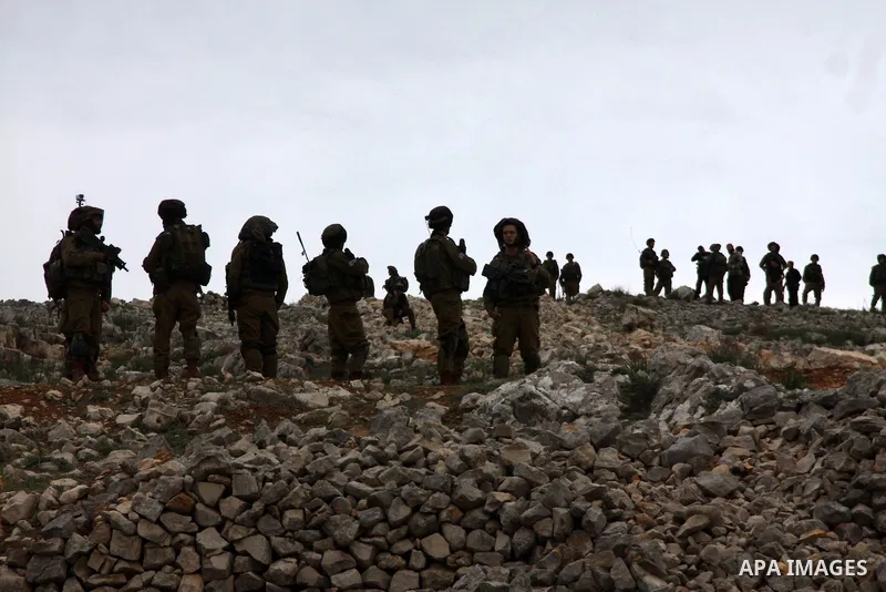 Israeli soldiers form a buffer between Palestinians and Israelis in a West Bank area between the Israeli settlement of Yitzhar and the Palestinian village of Burin, Tuesday, Jan. 14, 2014. Villagers said they were trying...