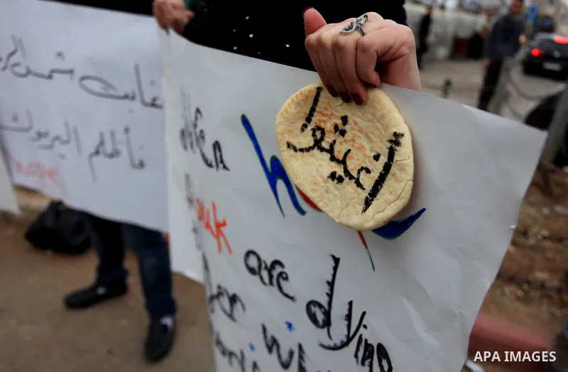 Palestinian protesters take part in a protest in solidarity with the Palestinian Yarmouk refugee camp in Syria, in the West Bank city of Ramallah, Tuesday, Jan. 14, 2014. Children, the elderly and others displaced by Syr...