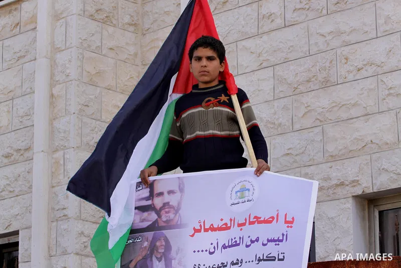 Members of the Palestine Scholars Association take part in a protest to show solidarity with Palestinian refugees in Syria's main refugee camp Yarmouk, in front of the Red Cross, in Gaza City on January 15, 2014. Photo b...