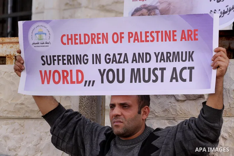 Members of the Palestine Scholars Association take part in a protest to show solidarity with Palestinian refugees in Syria's main refugee camp Yarmouk, in front of the Red Cross, in Gaza City on January 15, 2014. Photo b...