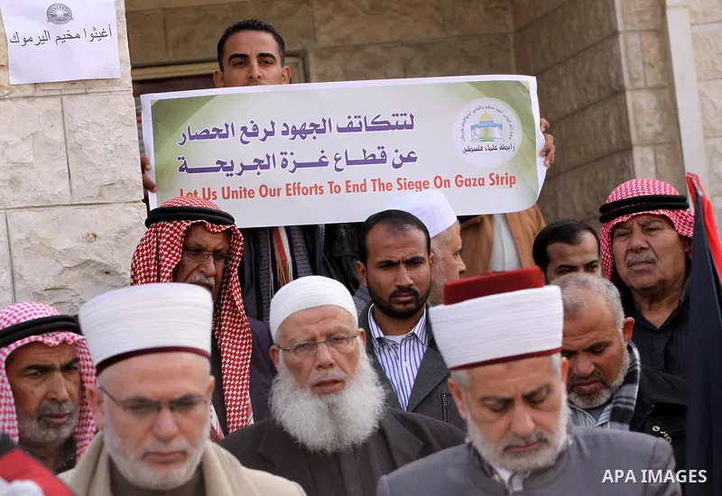 Members of the Palestine Scholars Association take part in a protest to show solidarity with Palestinian refugees in Syria's main refugee camp Yarmouk, in front of the Red Cross, in Gaza City on January 15, 2014. Photo b...