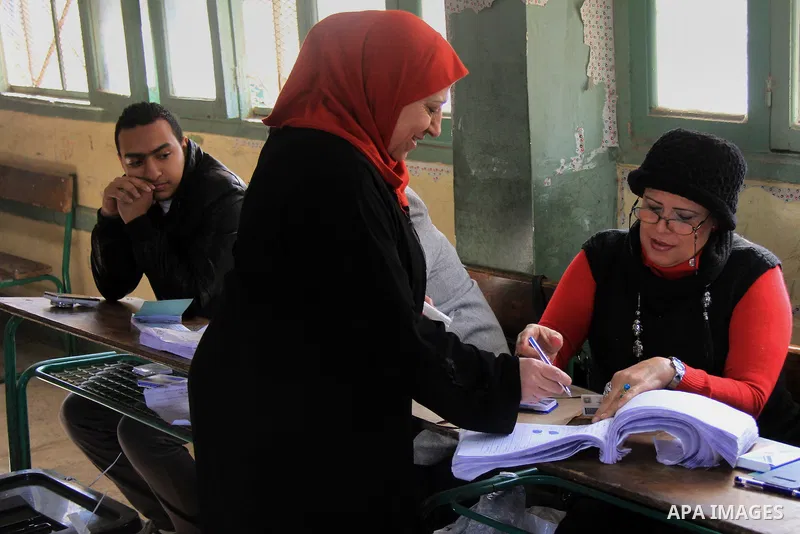 Egyptians cast their ballot at a polling station during the second day of voting on a new constitution on January 15, 2014 in the Nasr City district of the Egyptian capital, Cairo. Egyptians resumed voting in the constit...