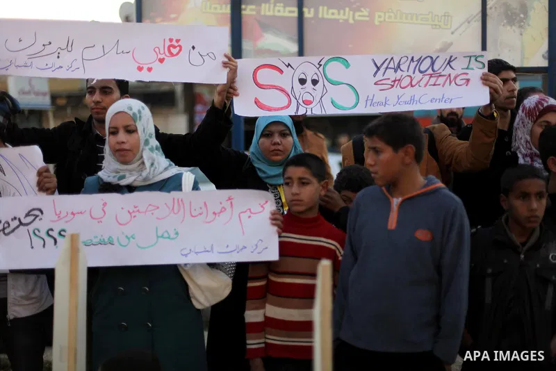 Palestinian children hold placards as they take part in a rally to show solidarity with Palestinian refugees in Syria's main refugee camp Yarmouk, in Deir al-Balah in the central Gaza Strip January 15, 2014. Photo by Ash...