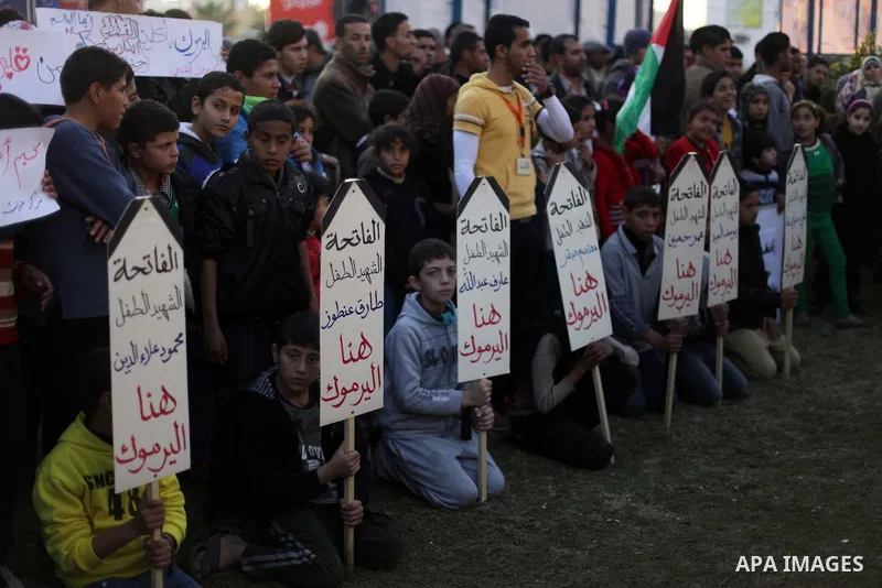 Palestinian children hold placards as they take part in a rally to show solidarity with Palestinian refugees in Syria's main refugee camp Yarmouk, in Deir al-Balah in the central Gaza Strip January 15, 2014. Photo by Ash...