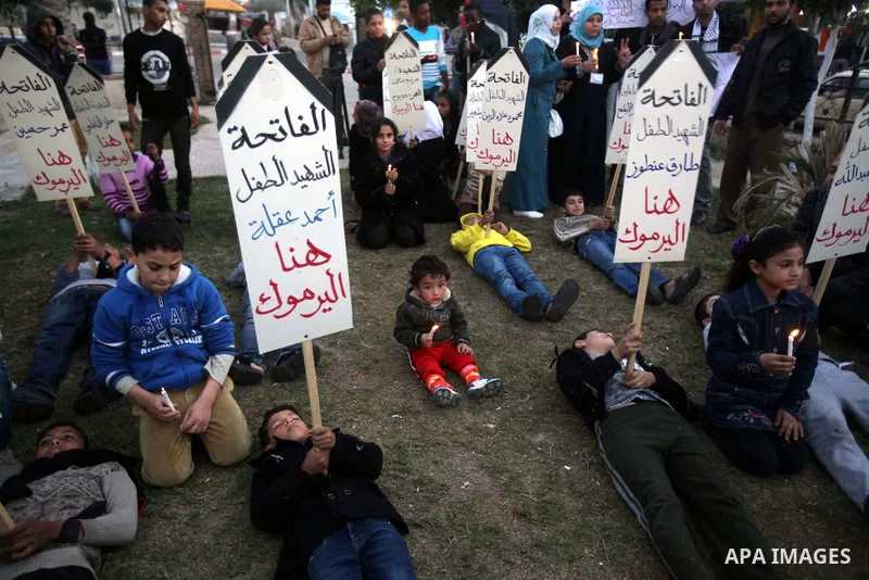 Palestinian children hold placards as they take part in a rally to show solidarity with Palestinian refugees in Syria's main refugee camp Yarmouk, in Deir al-Balah in the central Gaza Strip January 15, 2014. Photo by Ash...