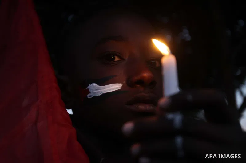 A Palestinian boy holds a candle as he takes part in a rally to show solidarity with Palestinian refugees in Syria's main refugee camp Yarmouk, in Deir al-Balah in the central Gaza Strip January 15, 2014. Photo by Ashraf...