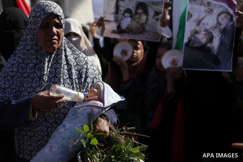 Palestinian women and children take part in a gathering to show solidarity with Palestinian refugees in Syria's main refugee camp Yarmuk, in Gaza City, on January 16, 2014. Gaza's Islamist rulers Hamas urged militants to...