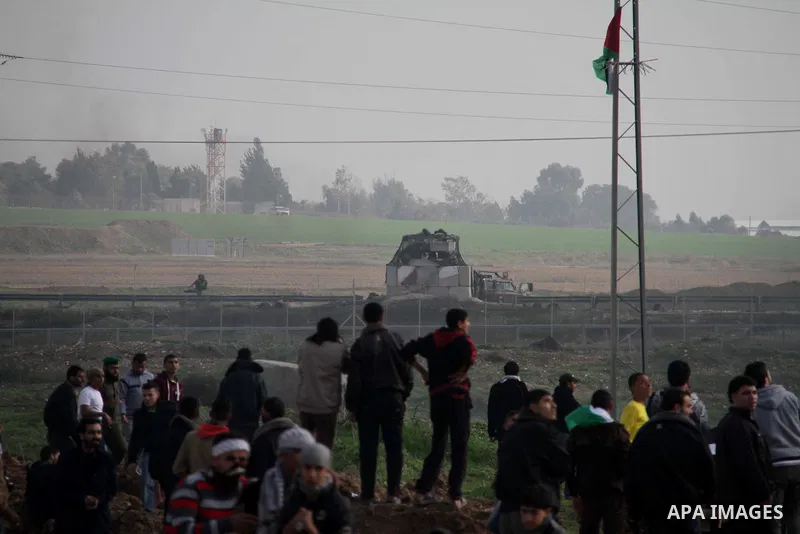 Palestinian protesters take part in a demonstration near the Nahal Oz border crossing with Israel, east of Gaza City on January 17, 2014. The Israeli army fired live rounds and tear gas at protesters near the border fenc...