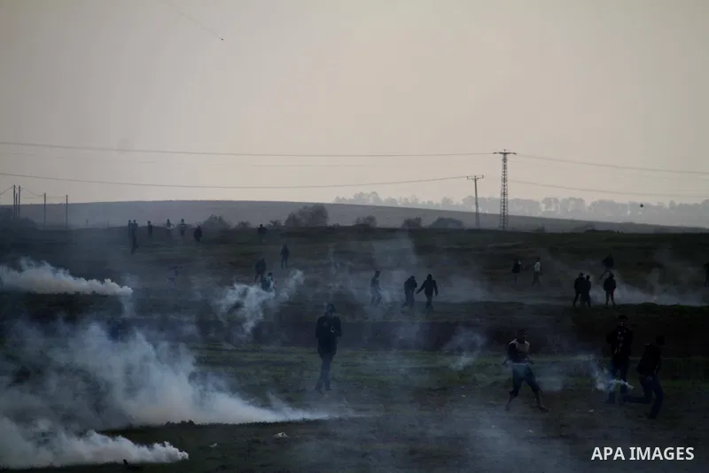 Palestinian protesters run away from tear gas fired by Israeli security forces during clashes near the Nahal Oz border crossing with Israel, east of Gaza City on January 17, 2014. The Israeli army fired live rounds and t...