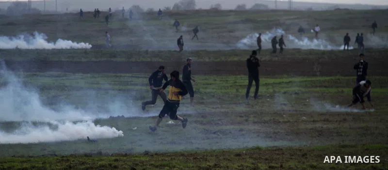 Palestinian protesters run away from tear gas fired by Israeli security forces during clashes near the Nahal Oz border crossing with Israel, east of Gaza City on January 17, 2014. The Israeli army fired live rounds and t...