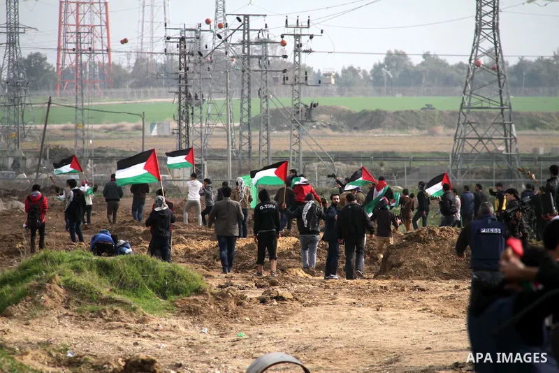 Palestinian protesters take part in a demonstration near the Nahal Oz border crossing with Israel, east of Gaza City on January 17, 2014. The Israeli army fired live rounds and tear gas at protesters near the border fenc...
