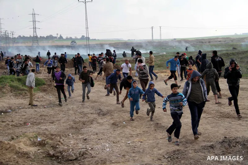 Palestinian protesters run away from tear gas fired by Israeli security forces during clashes near the Nahal Oz border crossing with Israel, east of Gaza City on January 17, 2014. The Israeli army fired live rounds and t...