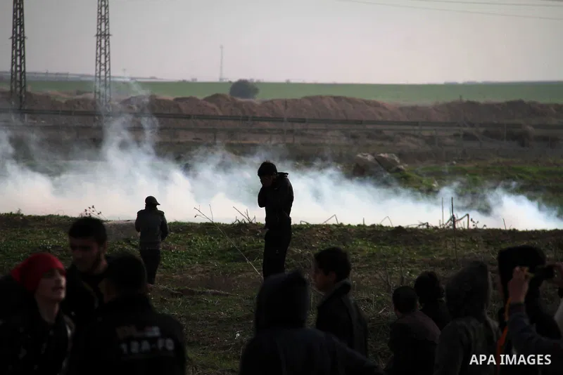 Palestinian protesters run away from tear gas fired by Israeli security forces during clashes near the Nahal Oz border crossing with Israel, east of Gaza City on January 17, 2014. The Israeli army fired live rounds and t...