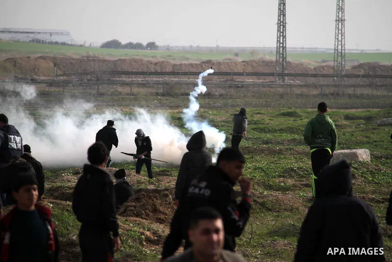 Palestinians throw back tear gas canister during clashes with Israeli forces near the Nahal Oz border crossing with Israel, east of Gaza City on January 17, 2014. The Israeli army fired live rounds and tear gas at protes...