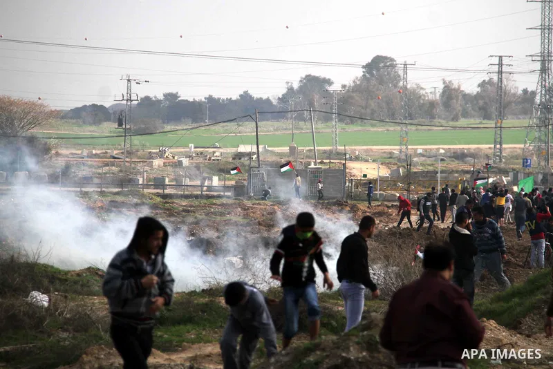 Palestinian protesters run away from tear gas fired by Israeli security forces during clashes near the Nahal Oz border crossing with Israel, east of Gaza City on January 17, 2014. The Israeli army fired live rounds and t...