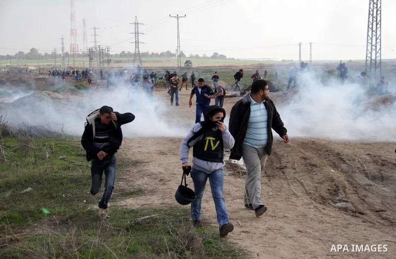 Palestinian protesters run away from tear gas fired by Israeli security forces during clashes near the Nahal Oz border crossing with Israel, east of Gaza City on January 17, 2014. The Israeli army fired live rounds and t...