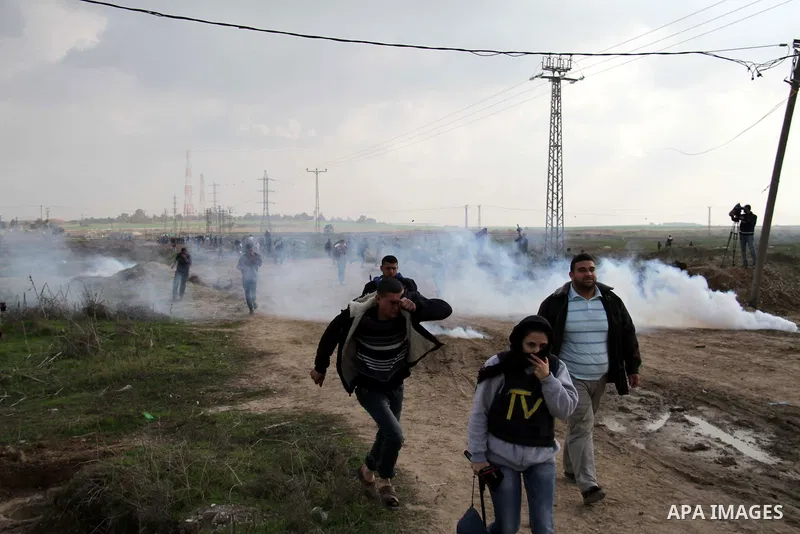 Palestinian protesters run away from tear gas fired by Israeli security forces during clashes near the Nahal Oz border crossing with Israel, east of Gaza City on January 17, 2014. The Israeli army fired live rounds and t...