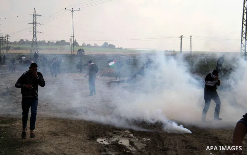 Palestinian protesters run away from tear gas fired by Israeli security forces during clashes near the Nahal Oz border crossing with Israel, east of Gaza City on January 17, 2014. The Israeli army fired live rounds and t...