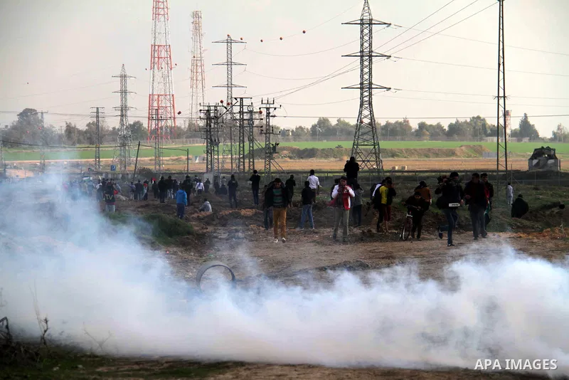 Palestinian protesters run away from tear gas fired by Israeli security forces during clashes near the Nahal Oz border crossing with Israel, east of Gaza City on January 17, 2014. The Israeli army fired live rounds and t...