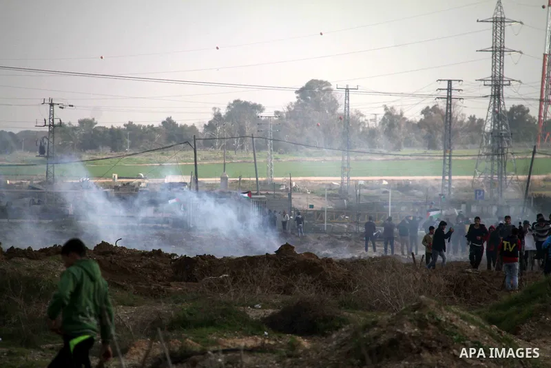 Palestinian protesters run away from tear gas fired by Israeli security forces during clashes near the Nahal Oz border crossing with Israel, east of Gaza City on January 17, 2014. The Israeli army fired live rounds and t...