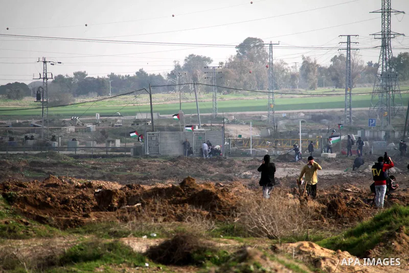 Palestinian protesters take part in a demonstration near the Nahal Oz border crossing with Israel, east of Gaza City on January 17, 2014. The Israeli army fired live rounds and tear gas at protesters near the border fenc...