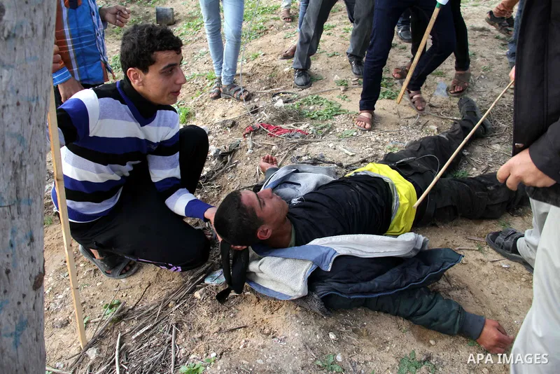 Palestinians carry a fellow protester wounded during clashes with Israeli forces near the Nahal Oz border crossing with Israel, east of Gaza City on January 17, 2014. The Israeli army fired live rounds and tear gas at pr...