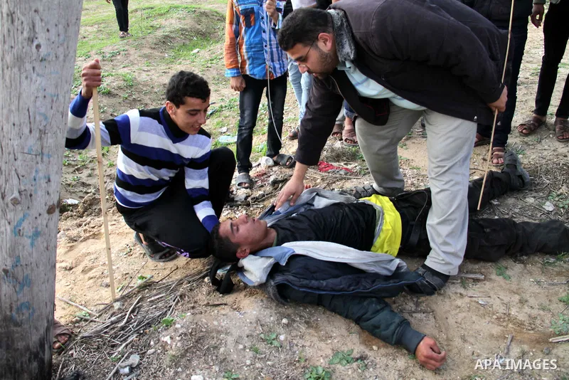 Palestinians carry a fellow protester wounded during clashes with Israeli forces near the Nahal Oz border crossing with Israel, east of Gaza City on January 17, 2014. The Israeli army fired live rounds and tear gas at pr...