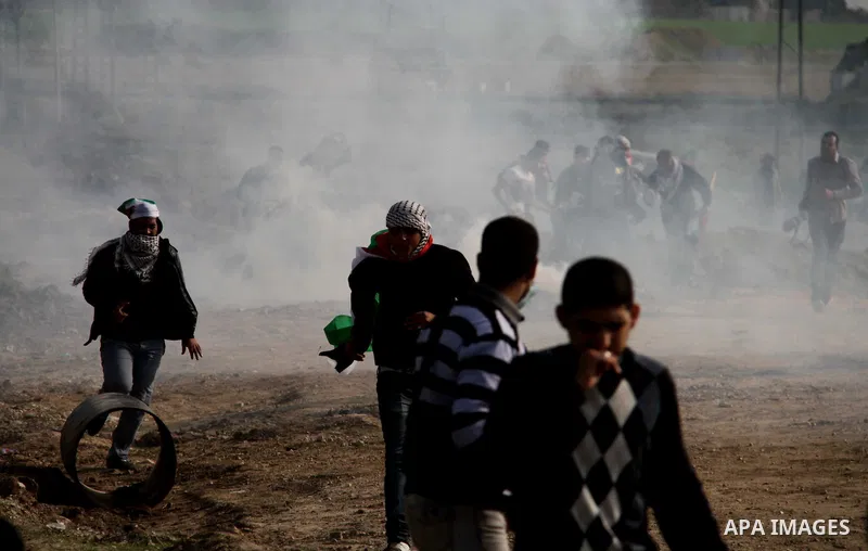 Palestinian protesters run away from tear gas fired by Israeli security forces during clashes near the Nahal Oz border crossing with Israel, east of Gaza City on January 17, 2014. The Israeli army fired live rounds and t...