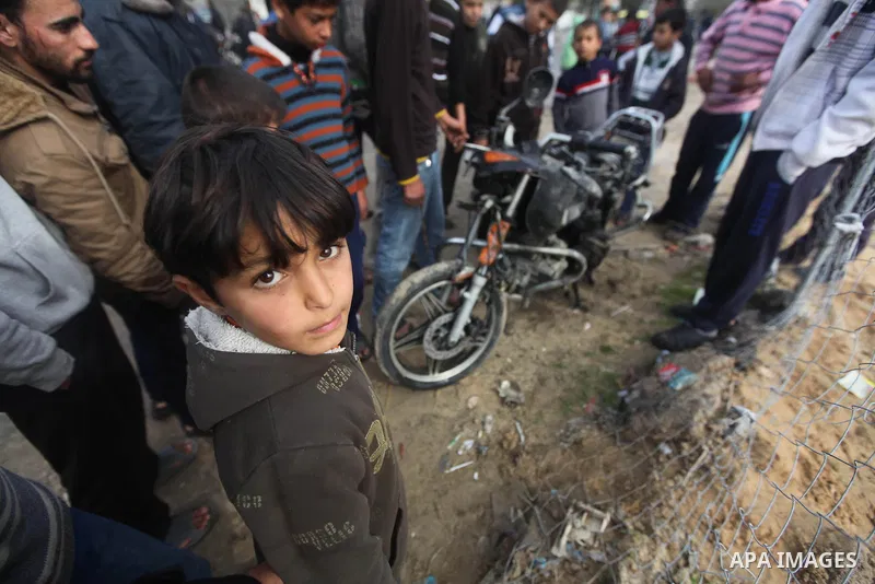 Palestinians gather around the wreckage of a motorcycle targeted overnight by an Israeli air strike, in Gaza City, on January 19, 2014. The Israeli army launched two air raids on the Gaza Strip overnight in retaliation a...