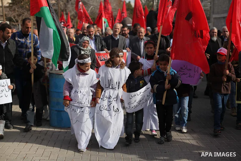 Supporters of the Democratic Front for the Liberation of Palestine take part in a protest to show solidarity with Palestinian refugees in Syria's main refugee camp Yarmouk, in Gaza City on January 19, 2014. Photo by Ashr...