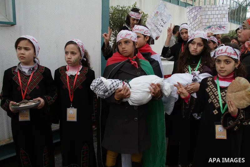 Palestinian children take part in a protest to show solidarity with Palestinian refugees in Syria's main refugee camp Yarmouk, in Gaza City on January 19, 2014. Photo by Ashraf Amra