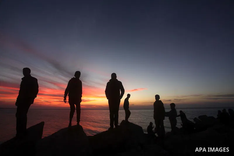 Palestinians watch the sunset as they spends their time at Gaza port in the west of Gaza City, 19 January 2014. Earlier on 19 January 2014, Israel launched two more airstrikes in Gaza which caused no injuries. Those were...