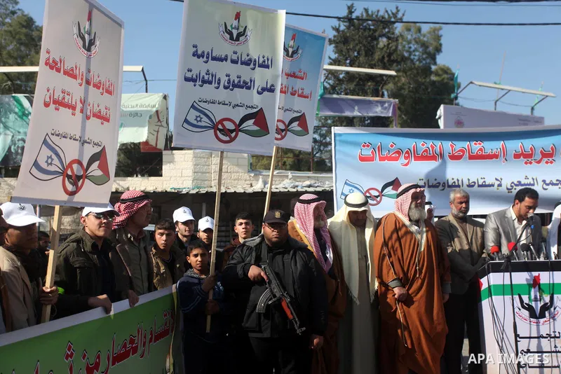 Palestinian protesters hold placards during a demonstration against resuming peace talks with Israel in Gaza City January 20, 2014. Under heavy American pressure, Israel and the Palestinians resumed peace talks after a f...
