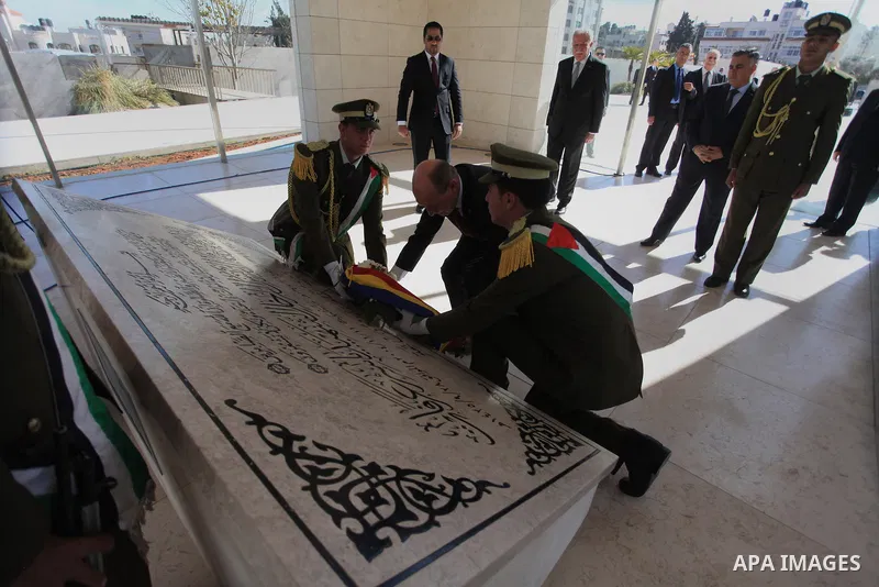 Romanian President Traian Basescu lays a wreath on the tomb of late Palestinian leader Yasser Arafat during a welcome ceremony in the West Bank town of Ramallah on January 21, 2014 before his meeting with Palestinian Aut...