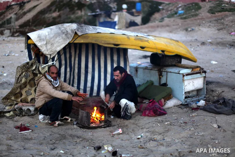 Palestinian fishermen warm themselves up around a firewood at the beach of Gaza City, on January 22, 2013. Photo by Ashraf Amra