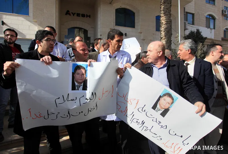 Palestinian doctors and employees of the Health ministry hold placards during a protest calling for the dismissal of the Minister of Health, in front of the supreme judicial council in the West Bank City of Ramallah Janu...