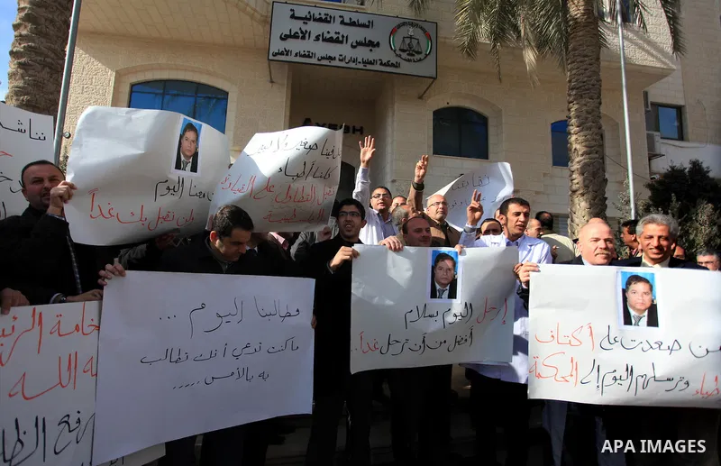 Palestinian doctors and employees of the Health ministry hold placards during a protest calling for the dismissal of the Minister of Health, in front of the supreme judicial council in the West Bank City of Ramallah Janu...