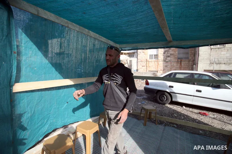 Palestinian Khaled Zir al-Husseini builds a tent in front of the Red Cross offices in Jerusalem, January 22, 2014. Al-Husseini lived in a cave since the demolition of his house by Israeli forces and leave it after the Is...