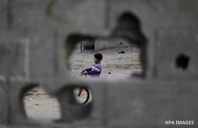 A Palestinian boy rides his bicycle outside his family's house at al-Shati refugee camp in the west Gaza City January 22, 2014. Photo by Emad Nassar