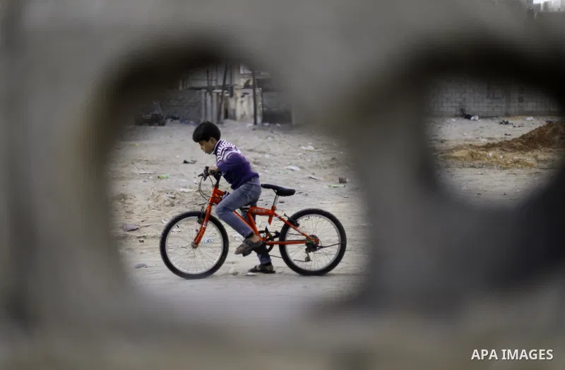 A Palestinian boy rides his bicycle outside his family's house at al-Shati refugee camp in the west Gaza City January 22, 2014. Photo by Emad Nassar