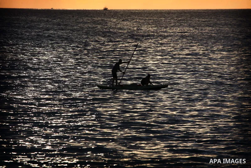Palestinian fishermen ride their fishing boat during the sunset at the beach of Gaza City, on January 23, 2014. Israeli Prime Minister Benjamin Netanyahu threatened Tuesday to teach Gaza's ruling Hamas movement a lesson...