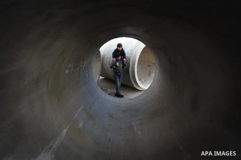 Palestinian children are seen through a cement tube playing at the beach of Gaza City, on January 23, 2014. Israeli Prime Minister Benjamin Netanyahu threatened Tuesday to teach Gaza's ruling Hamas movement a lesson "ver...