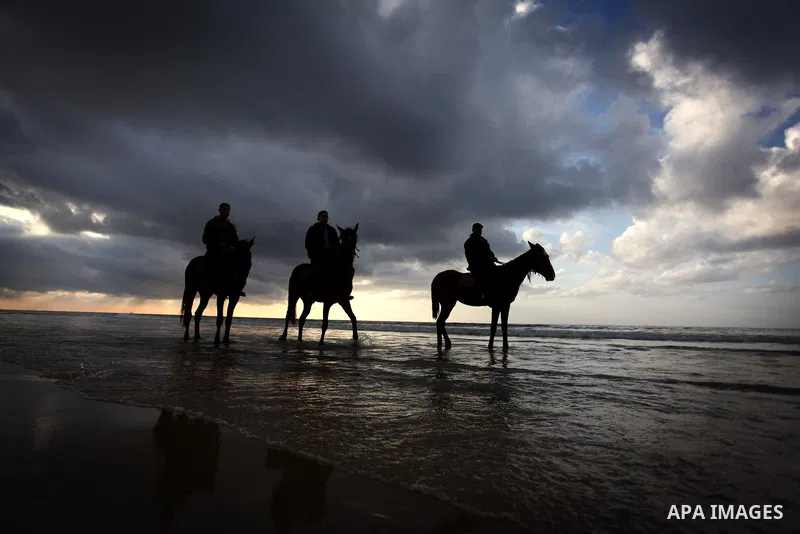 Palestinians ride their horses during the sunset along the seafront in Gaza City, on January 23, 2014. Israeli Prime Minister Benjamin Netanyahu threatened Tuesday to teach Gaza's ruling Hamas movement a lesson "very soo...