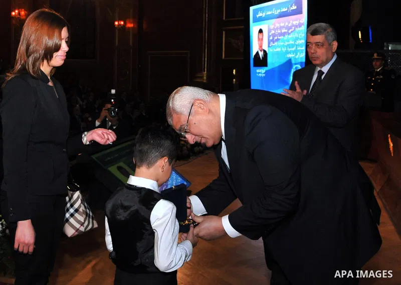 A handout picture released by Egyptian presidency shows Egypt's Interim President Adly Mansour honors the families of Egyptian policemen who were killed in the violence during the celebration of Police Day, in Cairo Janu...