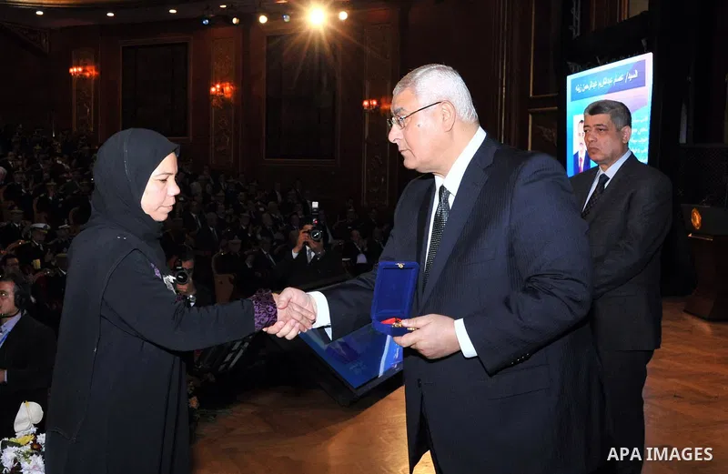 A handout picture released by Egyptian presidency shows Egypt's Interim President Adly Mansour honors the families of Egyptian policemen who were killed in the violence during the celebration of Police Day, in Cairo Janu...
