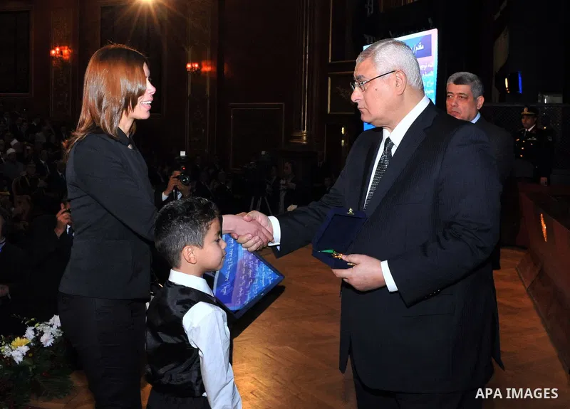 A handout picture released by Egyptian presidency shows Egypt's Interim President Adly Mansour honors the families of Egyptian policemen who were killed in the violence during the celebration of Police Day, in Cairo Janu...