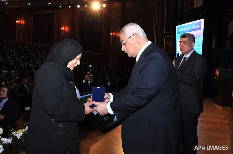 A handout picture released by Egyptian presidency shows Egypt's Interim President Adly Mansour honors the families of Egyptian policemen who were killed in the violence during the celebration of Police Day, in Cairo Janu...